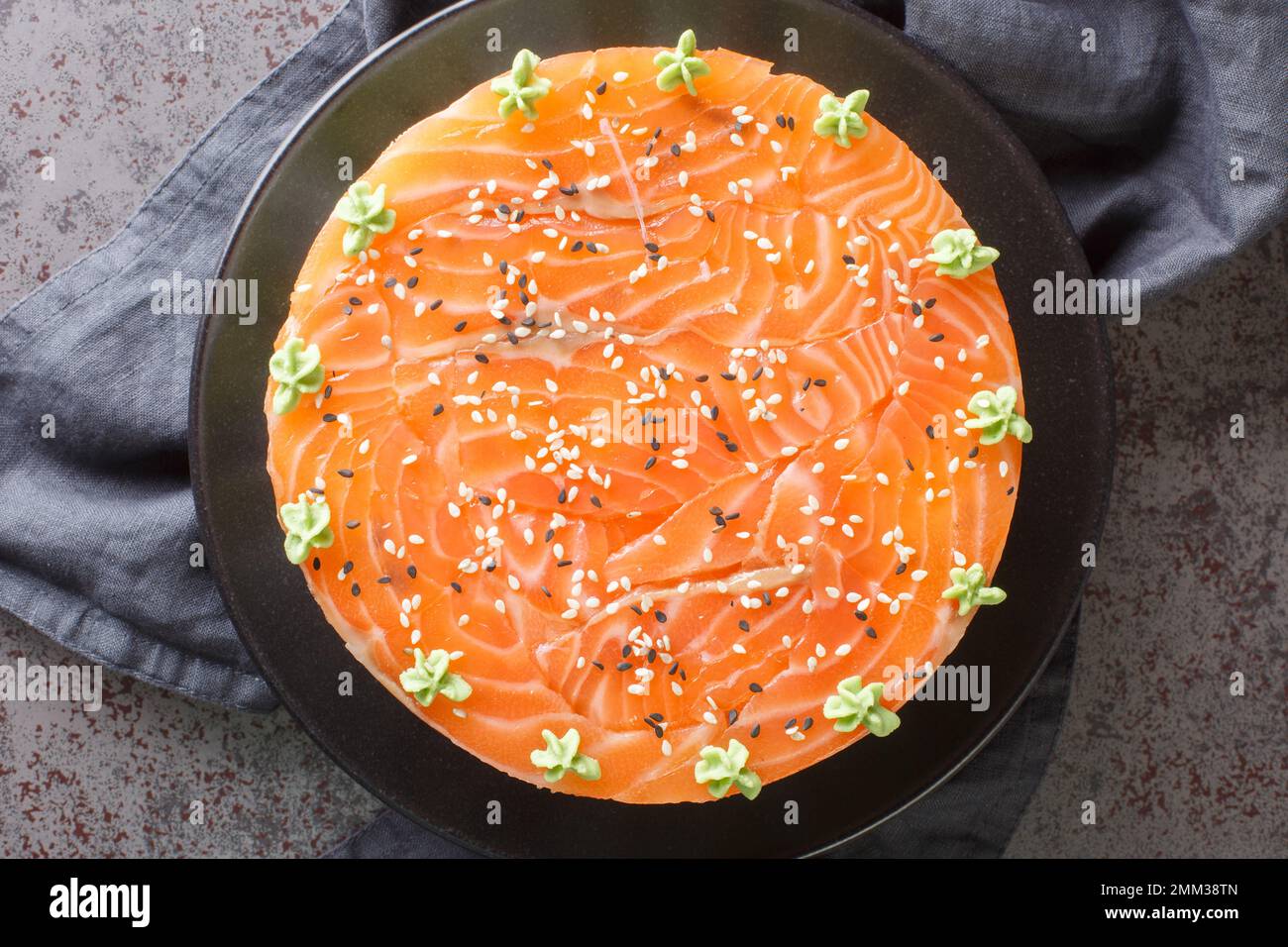 Sushi-Kuchen mit Lachs, Reis, Avocado und philadelphia-Käse auf dem Teller auf dem Tisch. Horizontale Draufsicht von oben Stockfoto