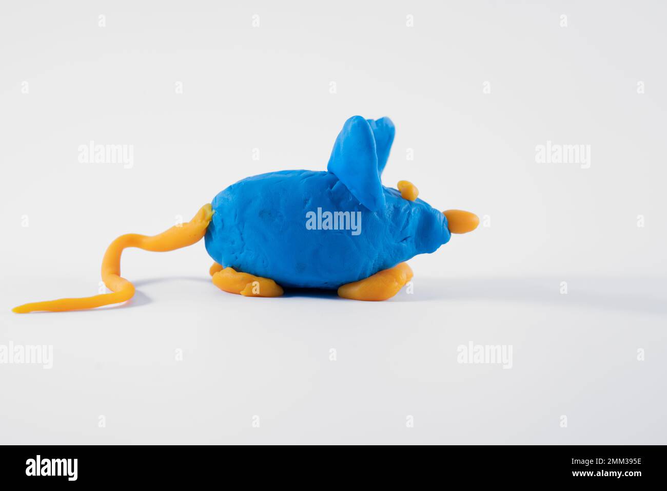 Blau-orangefarbenes handgemachtes Plasticin-Spielteigmodell einer auf weißem Hintergrund isolierten Maus Stockfoto
