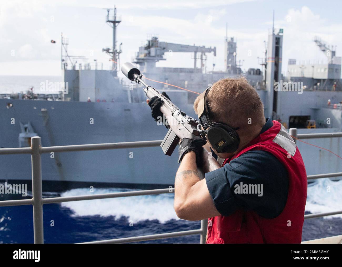 220915-N-TT639-1029 PHILIPPINISCHES MEER (SEPT 15, 2022) – Gunners Mate Seaman Justin Nelson aus Memphis, Tennessee, feuert eine Schusslinie zum Militär-Sealift-Kommando-Trocken- und Munitionsschiff USNS Carl Brashear (T-AKE 7) während einer Auffüllung auf See an Bord des amphibischen Angriffsträgers USS Tripoli (LHA 7) am 15. September 2022. Tripolis ist im Einsatzgebiet der US-Flotte von 7. tätig, um die Interoperabilität mit Verbündeten und Partnern zu verbessern und als einsatzbereite Einsatztruppe für den Frieden und die Stabilität in der Region Indo-Pazifik zu dienen. Stockfoto