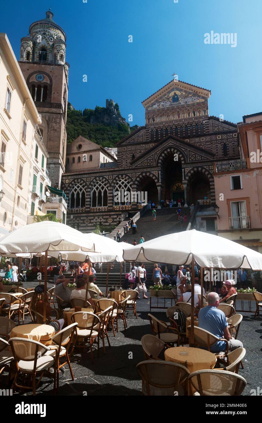 Touristen gehen die Treppe zur Kathedrale St. Andreas, Amalfi, Italien mit Cafétischen im Vordergrund Stockfoto