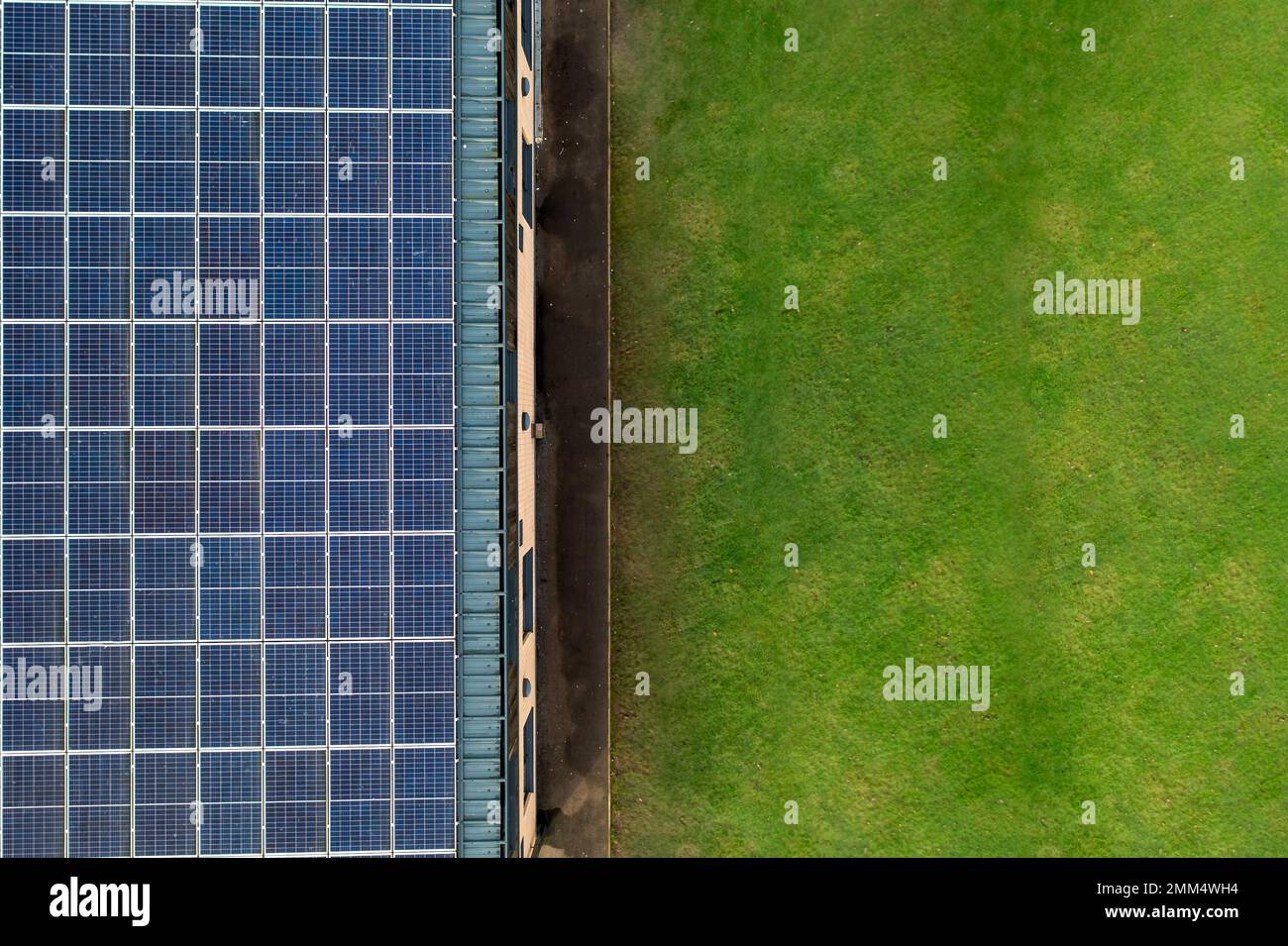 Luftaufnahme über einem umweltfreundlichen Haus, das während der Energiekrise saubere Elektrizität aus den Sonnenkollektoren auf dem Dach erzeugt Stockfoto