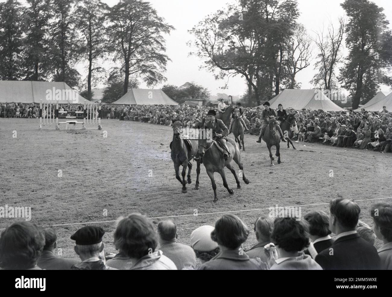 1960er, historisch, beobachtet von Zuschauern, Jugendliche auf Pferden, die auf einer Pferdeshow am Rande eines Feldes reiten, die auf dem Didsbury Agricultural Society Exhibition Grounds in der Nähe von Manchester, England, stattfindet. Die Show begann 1963 als lokale Veranstaltung, die Didsbury Light Horse Show, und findet heute noch in Didsbury statt. Stockfoto