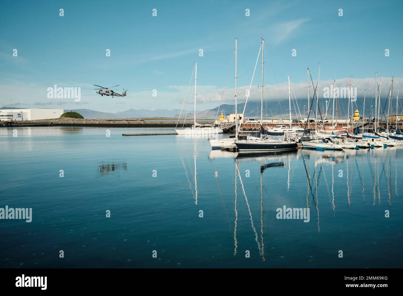 Hubschrauber, der in der Nähe von festgemachten Booten fliegt Stockfoto