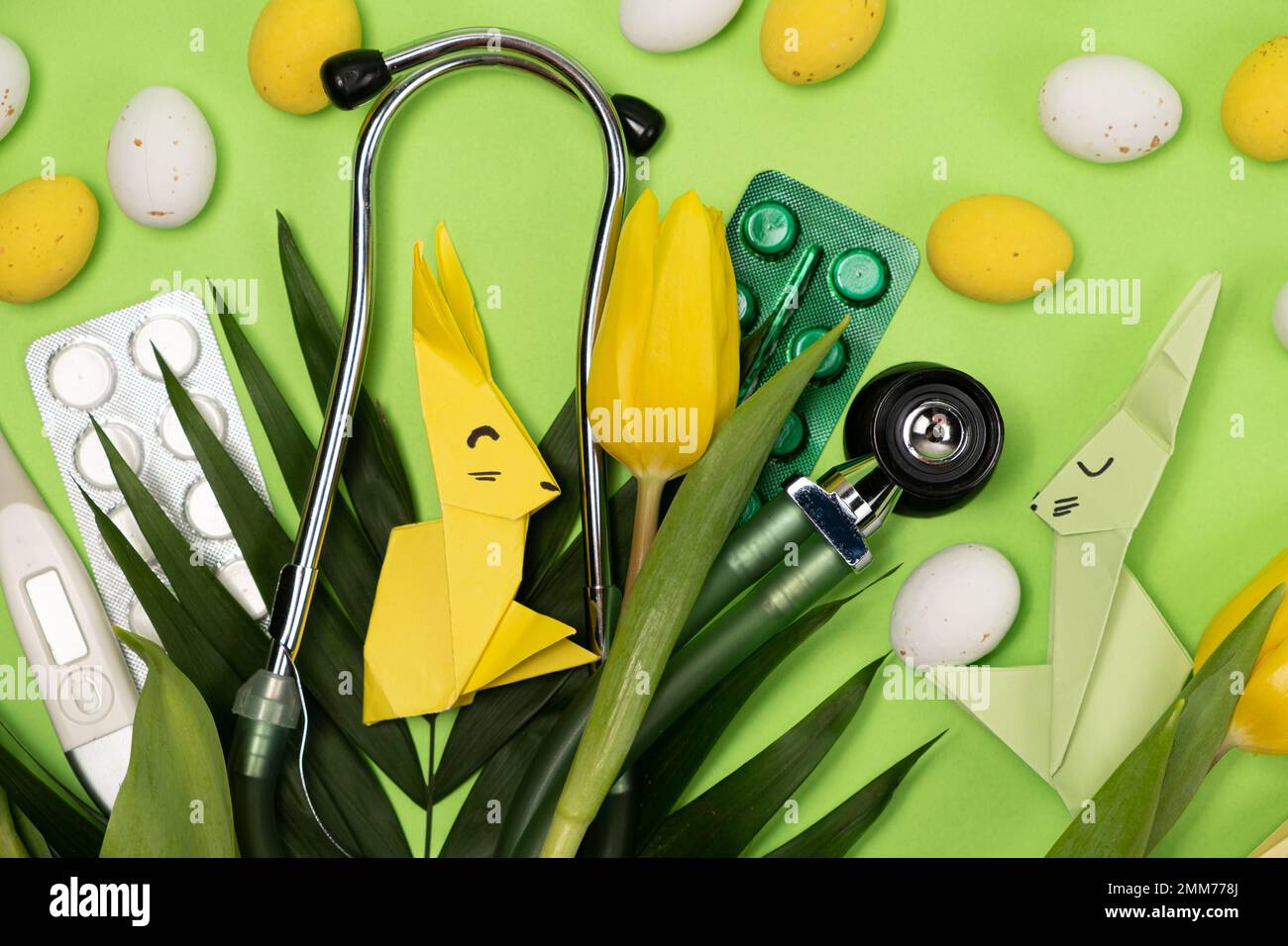 Fröhliche und gesunde Ostern - medizinische Karte mit Stethoskop und Pillen, Osterhasen und Eier Stockfoto