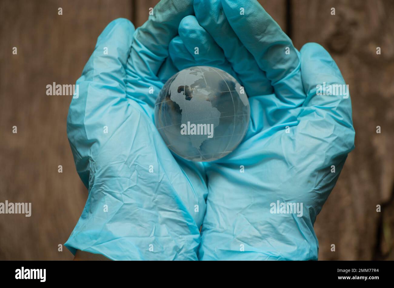 Hände in medizinischen Handschuhen mit einem Globus Stockfoto
