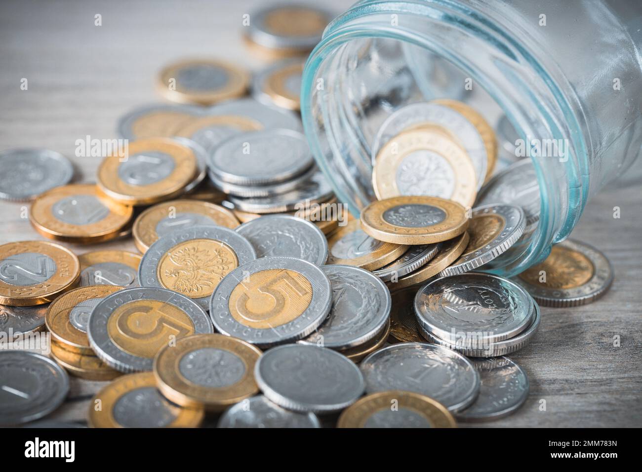 Aus dem Glas der Ersparnisse, polnisches Geld, verschüttete Zlotys, Piggy Bank, Sparen, Mitesser Stockfoto