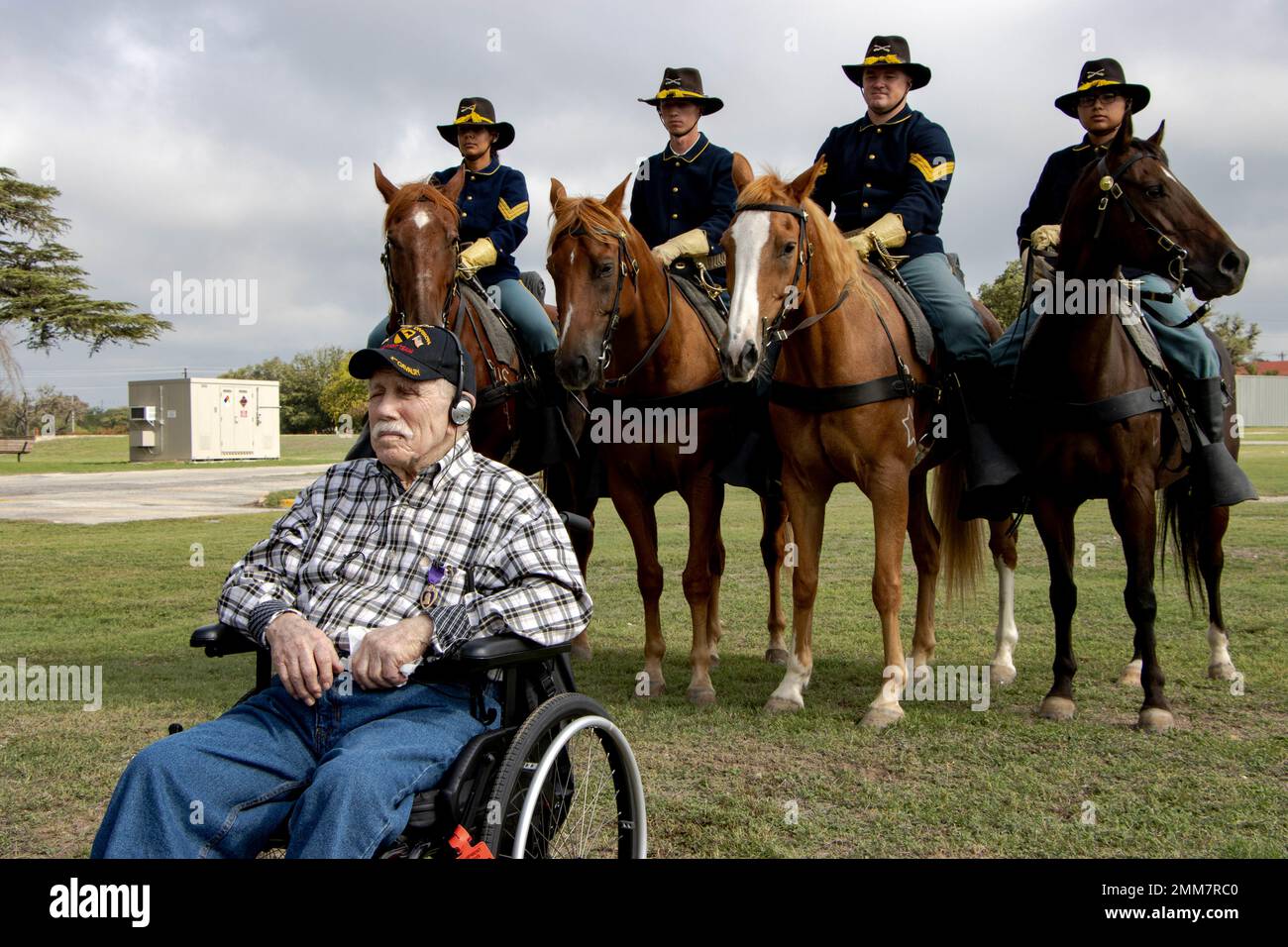 Pfc. (Ret.) James Hufnall posiert während seines 100. Geburtstags in Kerrville, Texas, vor berittenen Soldaten der 1. Kavallerie-Division, Horse Cavalry Detachment. Bei dieser Veranstaltung wurde Hufnall, der während des Zweiten Weltkriegs der 1. Brigade der 1. Kavallerie-Division zugeteilt wurde, mit dem Purple Heart ausgezeichnet. Geburtstag, Feier, Pferd, Troopers, VA, Zeremonie, Stockfoto