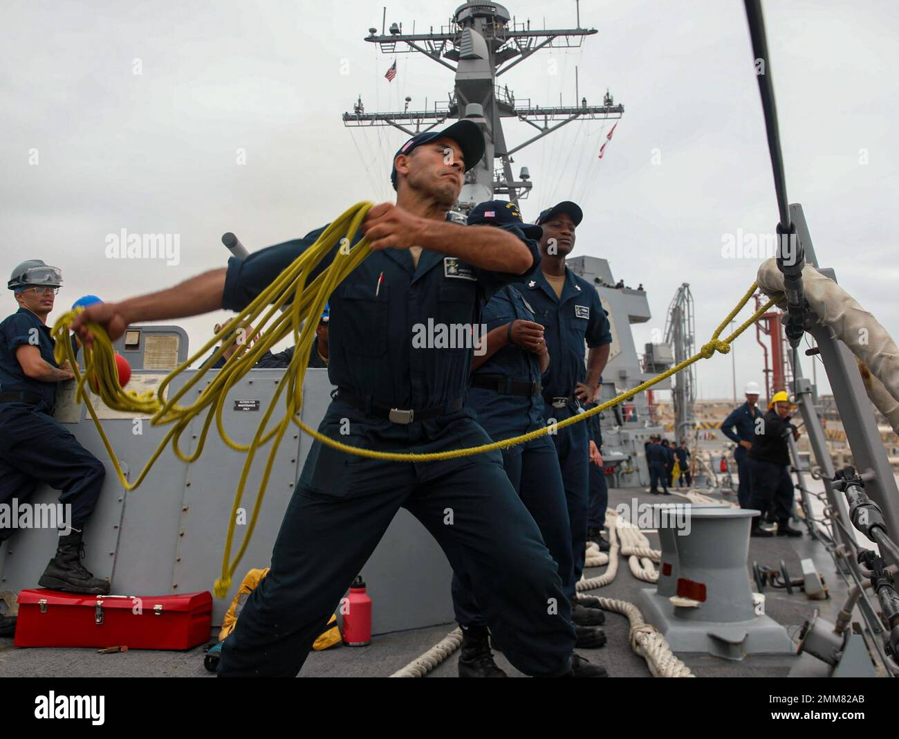 220915-N-UL352-1042 SALALAH, Oman (15. Sept. 2022) Seemann Ahmad Oulalla, der dem Zerstörer USS Delbert D. Black (DDG 119) zugeteilt wurde, wirft eine schwere Linie, während das Schiff am 15. Sept. in Salalah, Oman, anfährt. Delbert D. Black wird im US-5.-Flottengebiet eingesetzt, um die Sicherheit und Stabilität des Seeverkehrs im Nahen Osten zu gewährleisten. Stockfoto