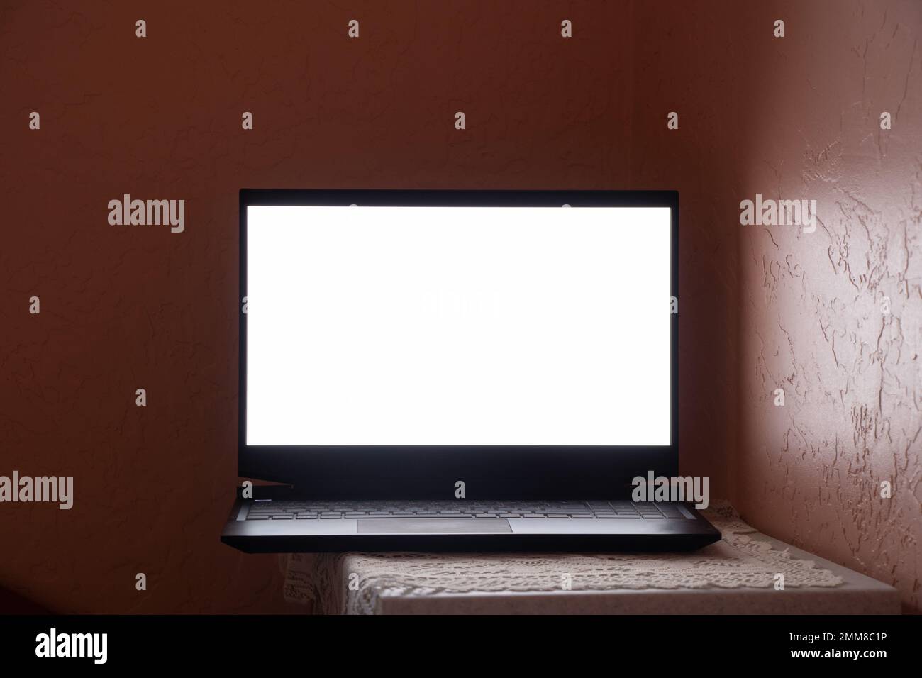 Laptop mit weißem Bildschirm steht am Arbeitsplatz auf einem Tisch zu Hause, Laptop auf einem Tisch, weißer Bildschirm Stockfoto