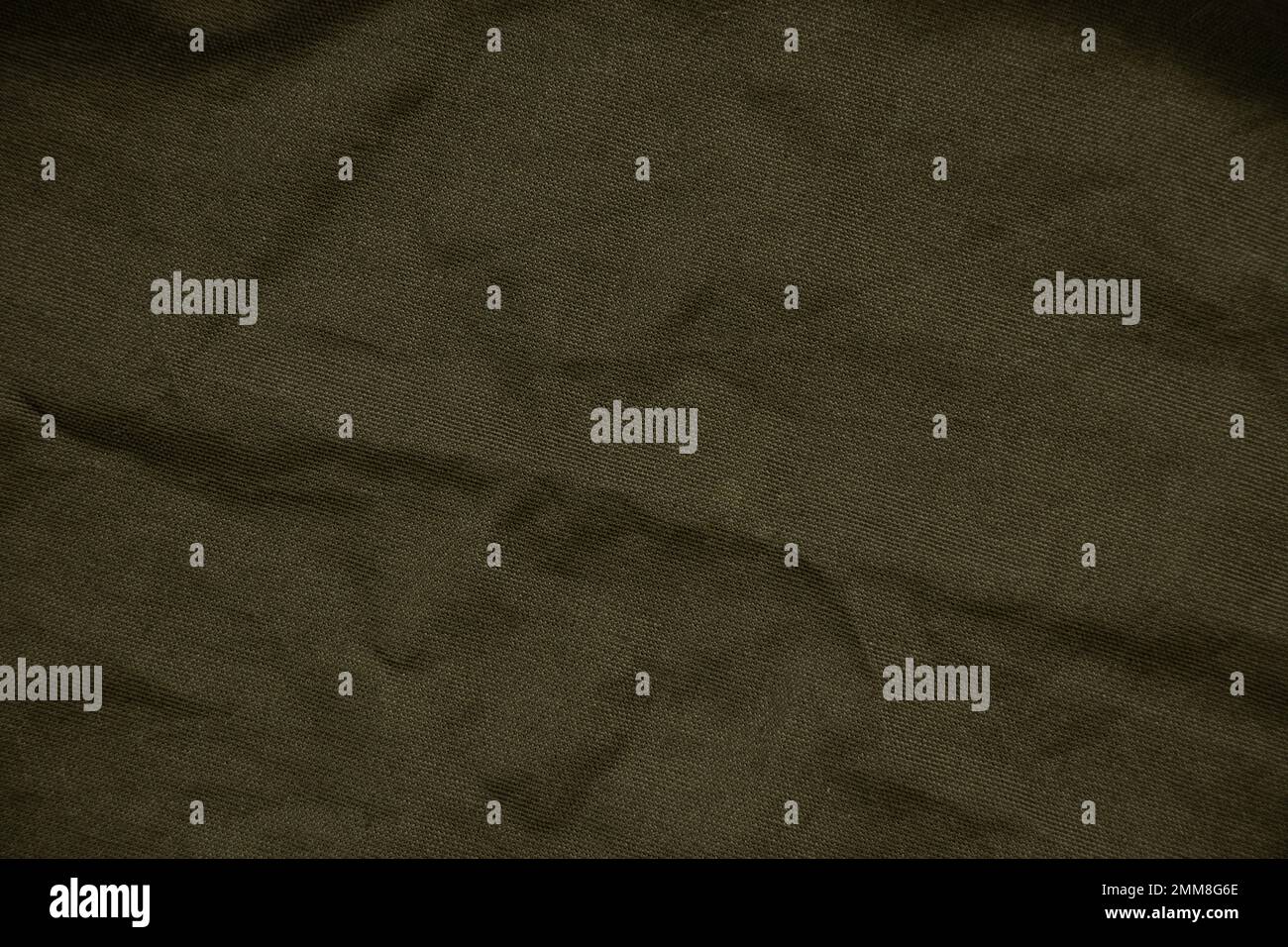 Dunkelgrüner, zerknitterter Stoff als Hintergrund, grüner Stoff Stockfoto