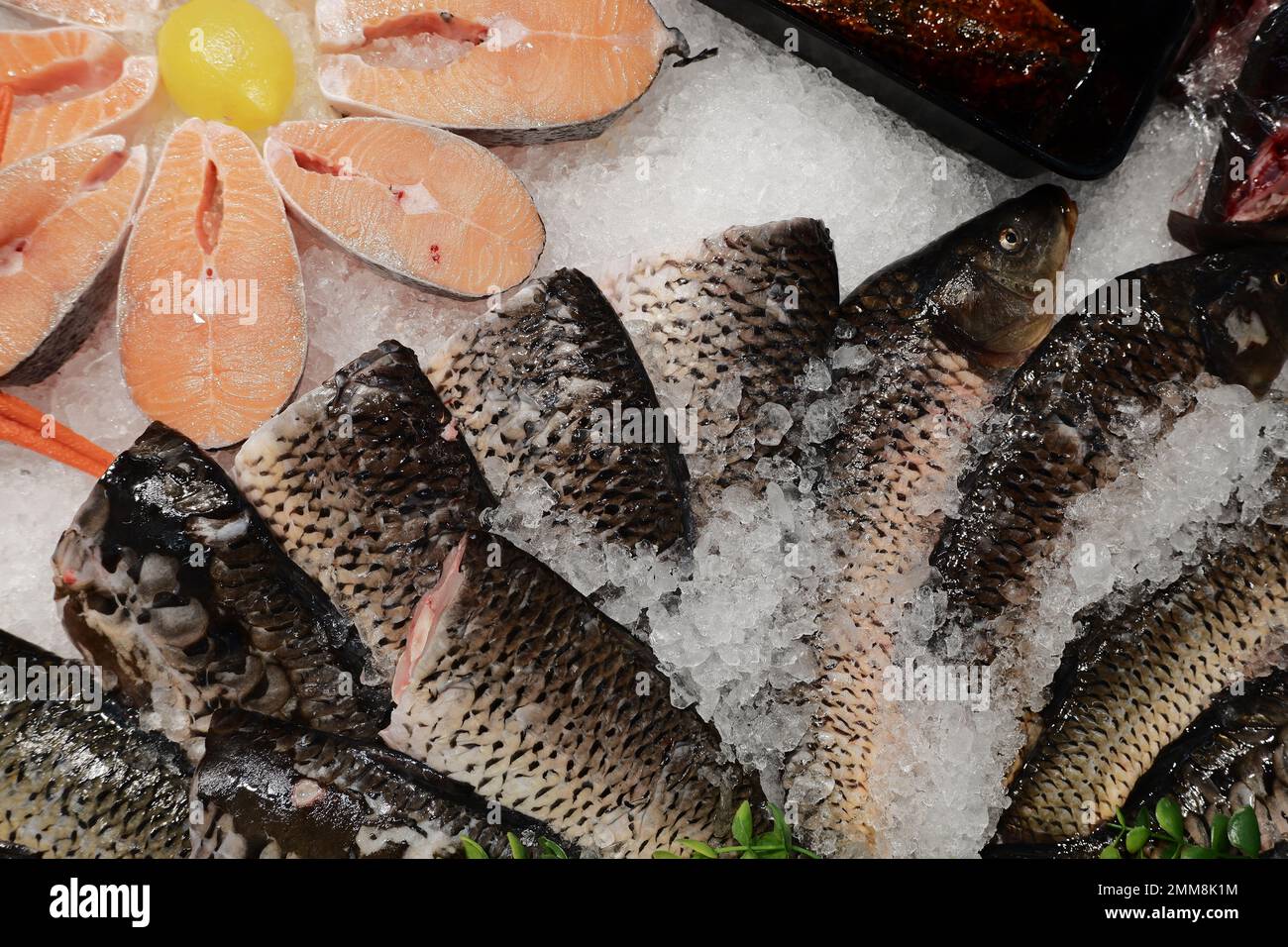 Wunderschön angelegter gefrorener Fisch in Form einer Blume auf dem Ladentisch. Gesundes Lebensmittelkonzept. Klassisches Chrom Stockfoto