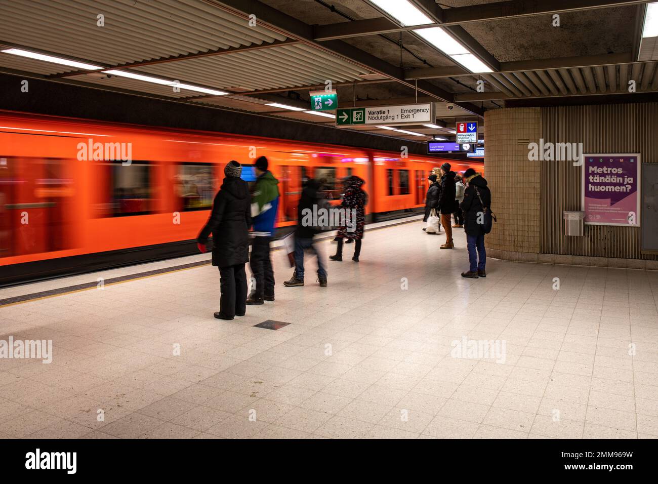 Menschen, die auf einen ankommenden U-Bahn-Zug in der U-Bahn-Station Rautatientori, Helsinki, Finnland warten Stockfoto