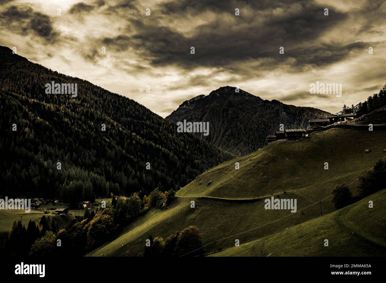 Alte Bauernhöfe auf einer Bergwiese mit Bergen im Hintergrund, Ulten-Tal, Merano, Südtirol, Italien Stockfoto
