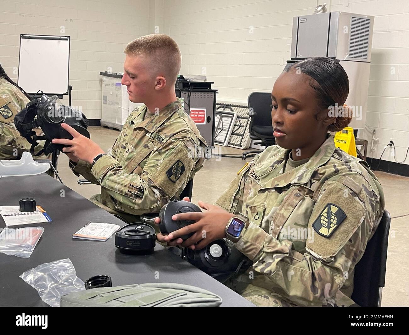 U.S. Army PFC. Caleb Watson (links) und PFC. Maryam Abdi-Razag (rechts), beide mit der 982. Combat Camera Company Airborne, identifizieren während des Trainings für chemische, biologische, radiologische, nukleare und Sprengstoffe mit der M50 Gasmaske während der Schlachtversammlung im September in East Point, GA, am 16. September 2022 verschiedene Fächer der M50 Gasmaske. Chemische, biologische, radiologische, nukleare und explosive Ausbildung ist für Armeesoldaten unerlässlich, um sich auf chemische Kriegsführung vorzubereiten. Stockfoto