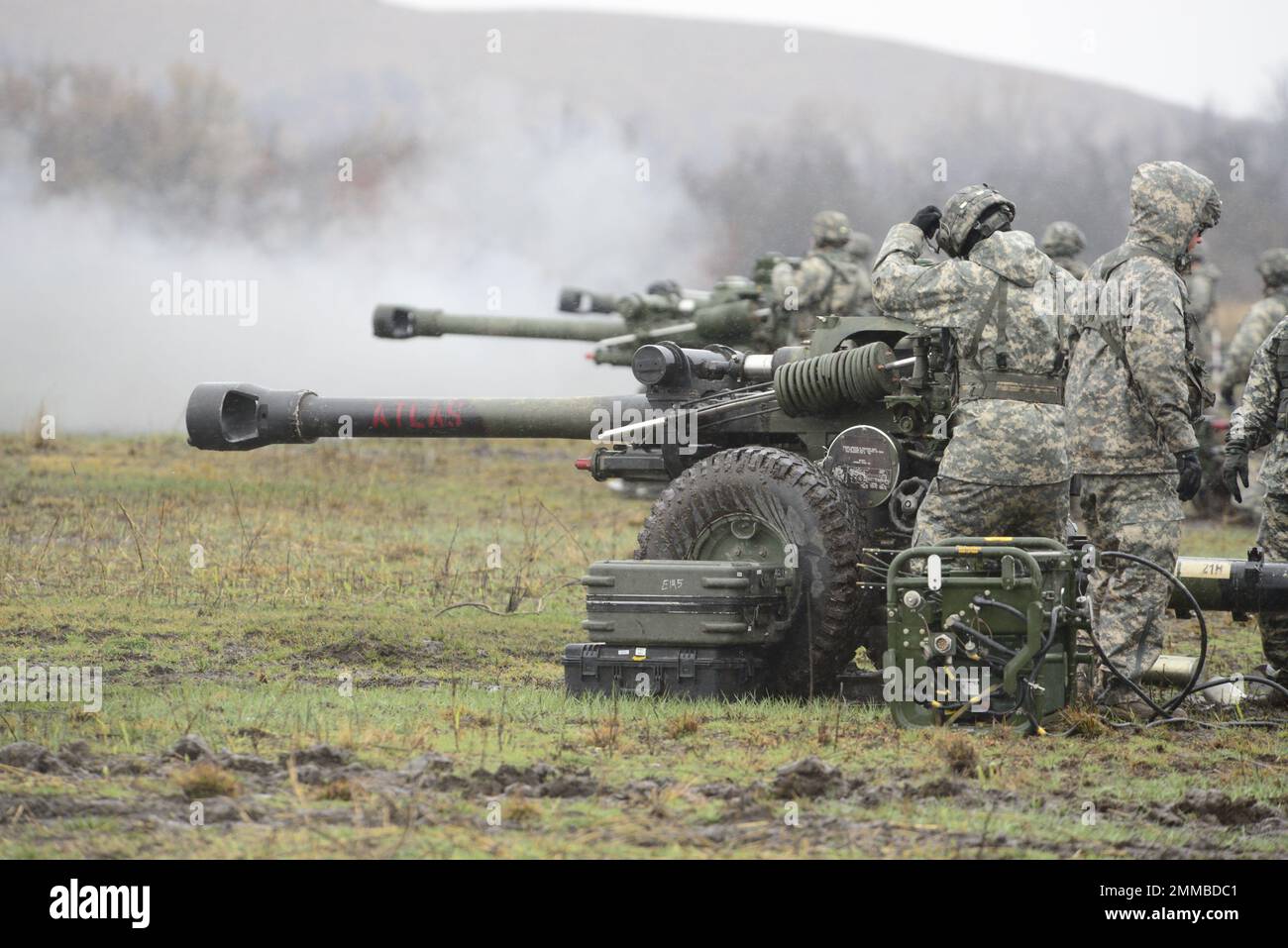 Direkte Feuerübung bei kaltem Nieselwetter durch 2. Bataillon, 2. Artillerie-Brigade, die 105mm Granaten von M119A3-Haubitzen aus nächster Nähe abfeuert, Stockfoto