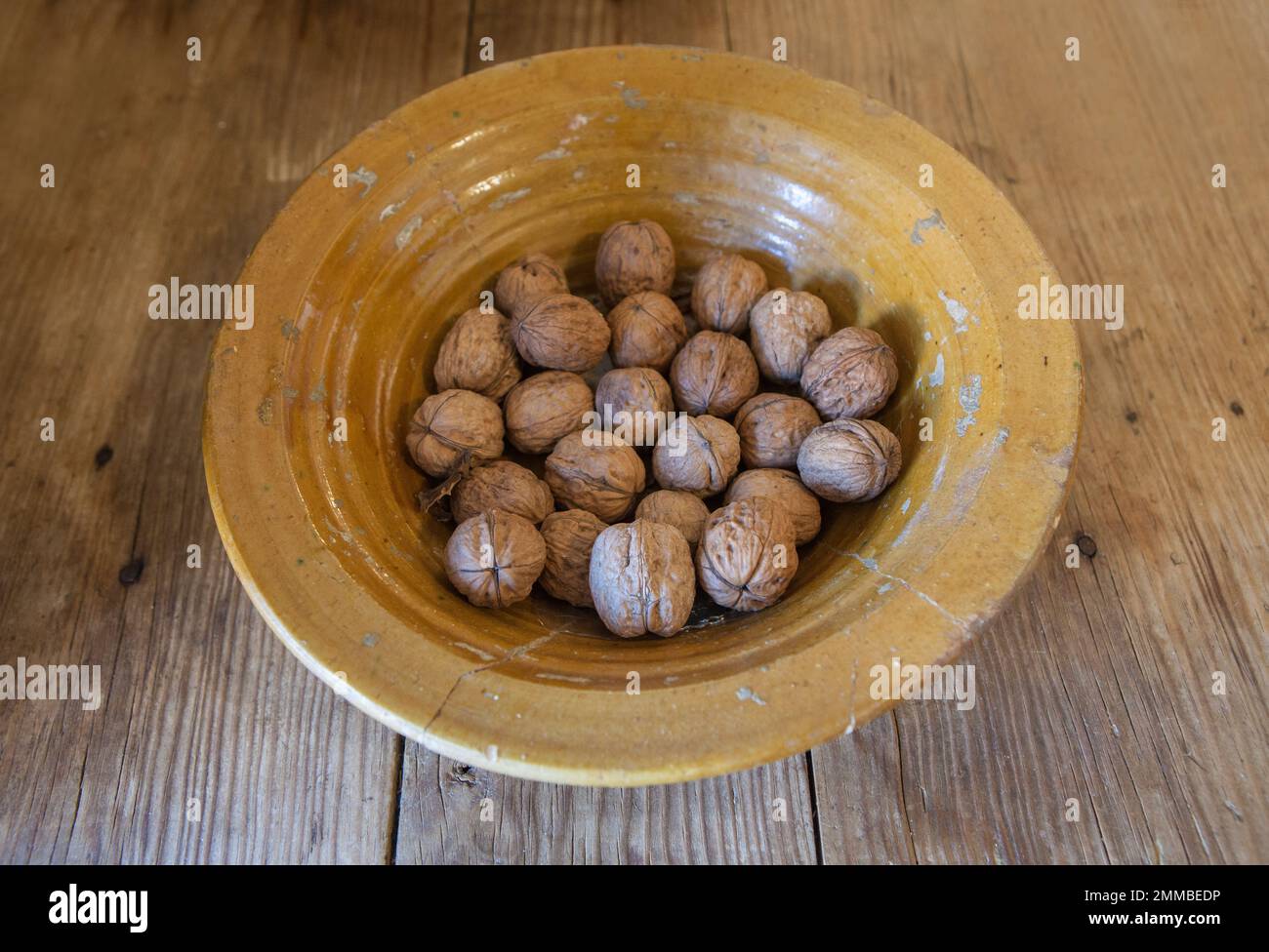 Glasierte Tonplatte voller Walnüsse. Selektiver Fokus Stockfoto