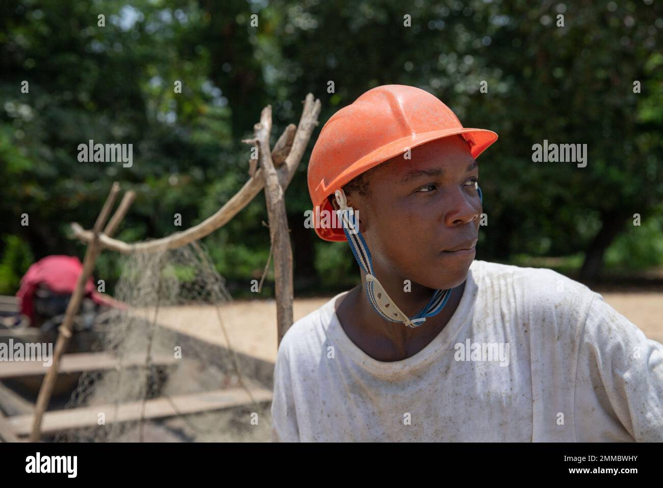 Porträt eines jungen afrikanischen Fischers, der Schutzhelm trägt und sich umsieht Stockfoto