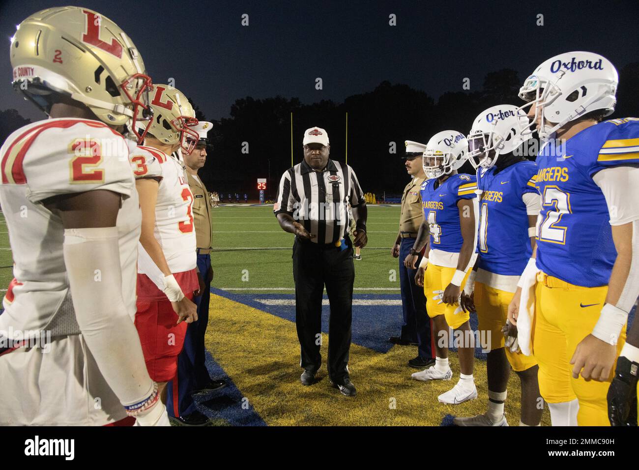 Ein Schiedsrichter der Mississippi High School Athletic Association präsentiert die offizielle Münze der Great American Rivalry Series auf der jährlichen Crosstown Classic Fußballspielmünze an der Oxford Junior High School in Oxford, Mississippi, 16. September 2022. GARS hebt langjährige Rivalitäten in der High School durch eine Reihe von Fußballspielen im ganzen Land hervor, zusammen mit der Möglichkeit für einzelne Spieler, Scholar Athlete und die wertvollsten Player Awards zu erhalten. Die Oxford Chargers treten jedes Jahr im Crosstown Classic Rivalry-Fußballspiel gegen die Lafayette Commodores an. Stockfoto