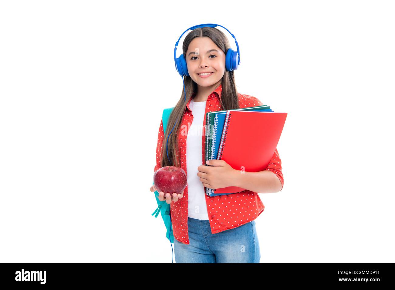 Schulmädchen, Teenager 12, 13, 14 Jahre alt, in Kopfhörern und Büchern auf isoliertem Studiohintergrund. Schulkinder mit Rucksack. Porträt von glücklichen Lächeln Stockfoto