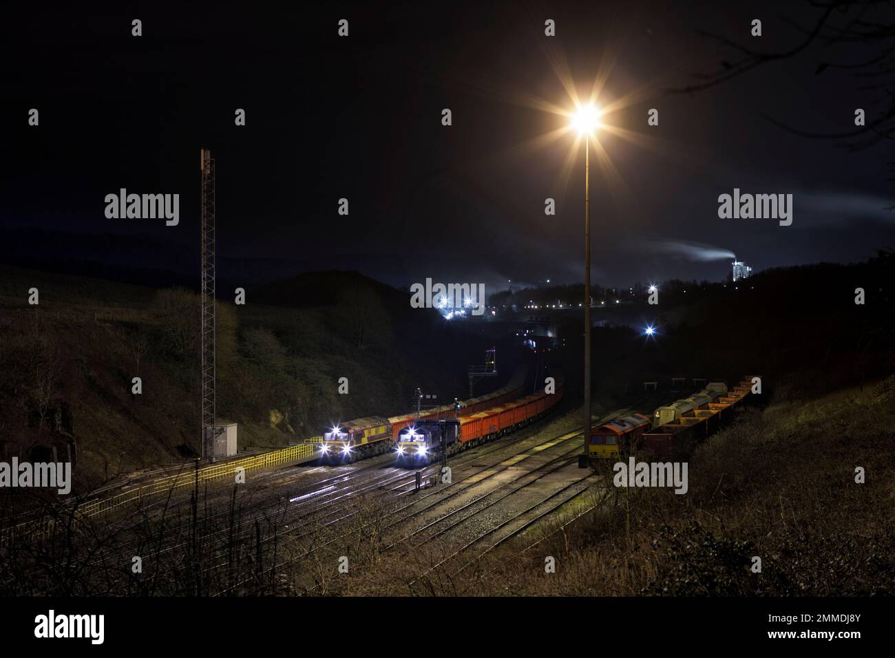 DB Cargo Rail UK Klasse 66 Diesellokomotiven warten mit Güterzügen, die Steinbrüche in Peak Forest, Buxton, Derbyshire, UK befördern Stockfoto