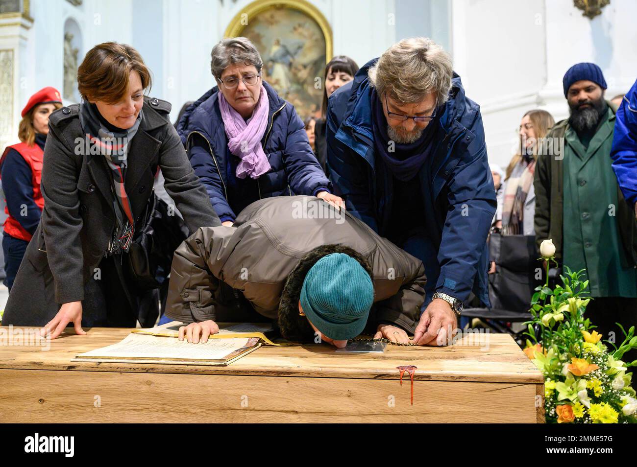 Palermo, Italien. 17. Januar 2023. Maria Conte (C) küsst während der offiziellen Beerdigung des verstorbenen Missionars das Plakat mit dem Namen ihres Sohnes. Offizielle Beerdigung des Laienmissionars Biagio Conte, der am 12. Januar 2023 starb. Die Feier für den Gründer der Hope and Charity Mission (Missione Speranza e Carità) für Armut und Obdachlosigkeit in Palermo fand in der Kathedrale „Santa Vergine Maria Assunta“ in Anwesenheit von Vertretern verschiedener religiöser Traditionen und Behörden statt. Kredit: SOPA Images Limited/Alamy Live News Stockfoto