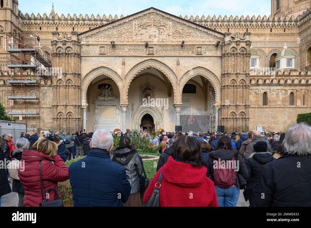 Menschen, die außerhalb der Kathedrale während der offiziellen Beerdigung des verstorbenen Missionars Biagio Conte eine Leinwand mit einem kurzen Film über Biagio Conte sehen. Offizielle Beerdigung des Laienmissionars Biagio Conte, der am 12. Januar 2023 starb. Die Feier für den Gründer der Hope and Charity Mission (Missione Speranza e Carità) für Armut und Obdachlosigkeit in Palermo fand in der Kathedrale „Santa Vergine Maria Assunta“ in Anwesenheit von Vertretern verschiedener religiöser Traditionen und Behörden statt. (Foto: Valeria Ferraro/SOPA Images/Sipa USA) Stockfoto