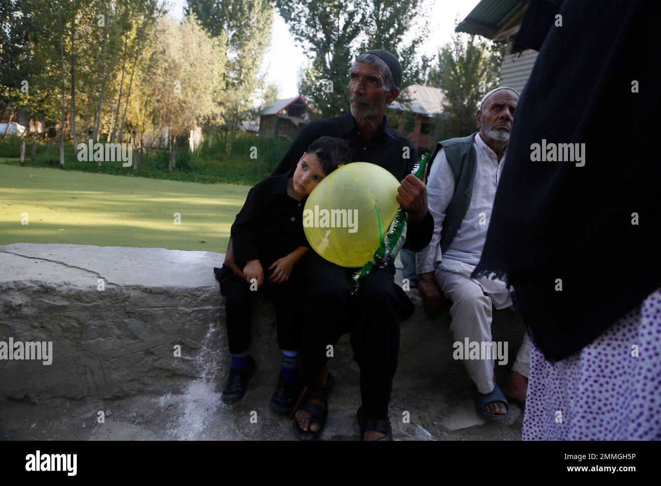 A Kashmiri Shiite Muslim watches a Muharram procession in Srinagar ...