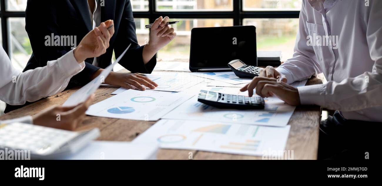Wirtschaftsdiskussionen, Business-Team analysiert Einkommensdiagramme und -Diagramme, um Marketingkonzepte mithilfe von Computer-Laptop und Taschenrechner zu planen Stockfoto