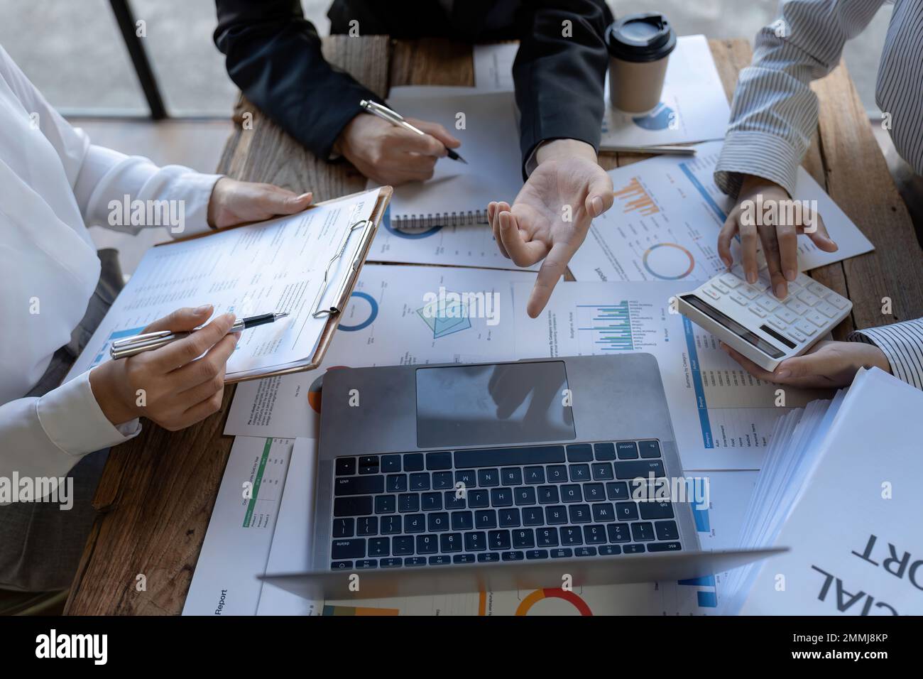 Finanzabteilung oder Buchhalter des Geschäftsteams, die mit einem Rechner arbeiten, um einen zusammenfassenden Bericht über Geschäftsdaten, ein Buchhaltungsdokument und einen Laptop-Computer unter zu berechnen Stockfoto