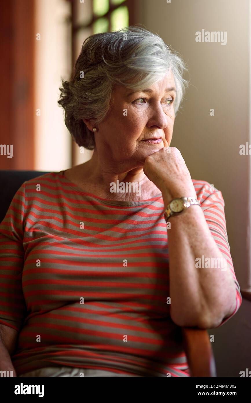 Manche nennen es Bedauern, andere nennen es Lebensunterricht. Eine ältere Frau, die zuhause aufmerksam aussieht. Stockfoto