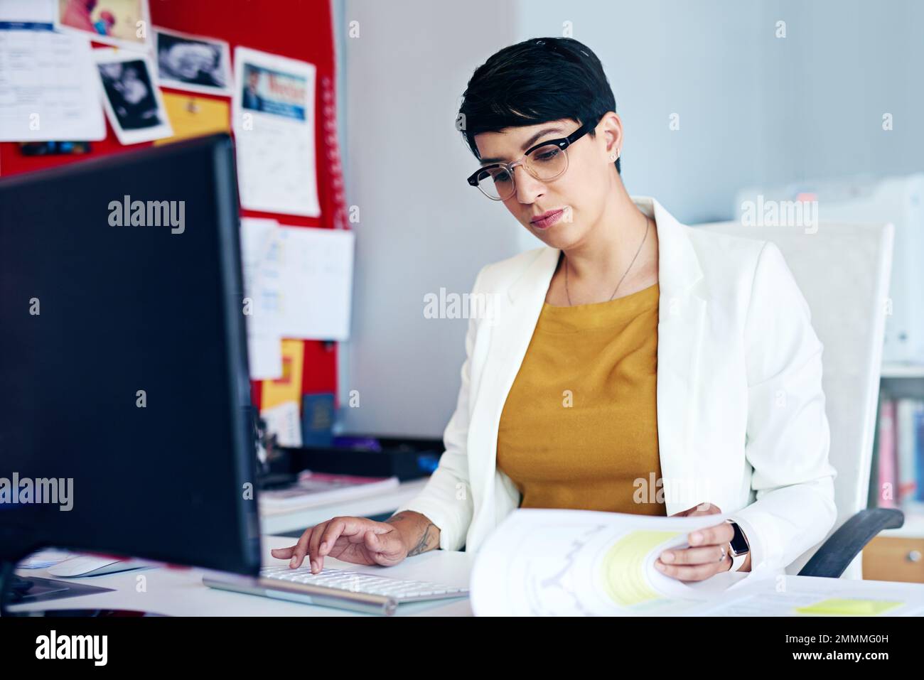 Kommen wir zum kleinsten Teil des Vertrags. Eine junge Geschäftsfrau, die an ihrem Schreibtisch arbeitet. Stockfoto