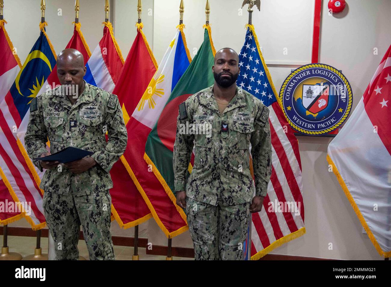 220921-N-JC800-002 SINGAPUR (21. September 2022) - (von links) Master Chief Information Systems Technician Arthur Dunford, zugewiesen an Commander, Logistics Group Western Pacific/Task Force 73, befördert Information Systems Technician 2. Class Theo Shipp während einer Beförderungszeremonie am 22. September an First Class Petty Officer. Stockfoto