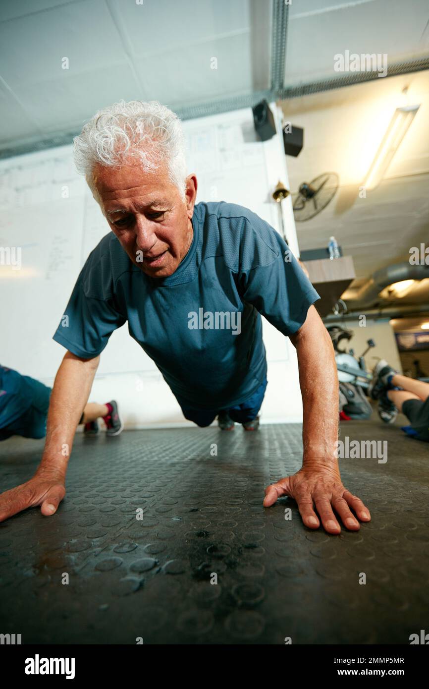Älter werden, fitter werden. Ein älterer Mann, der im Fitnessstudio trainiert. Stockfoto