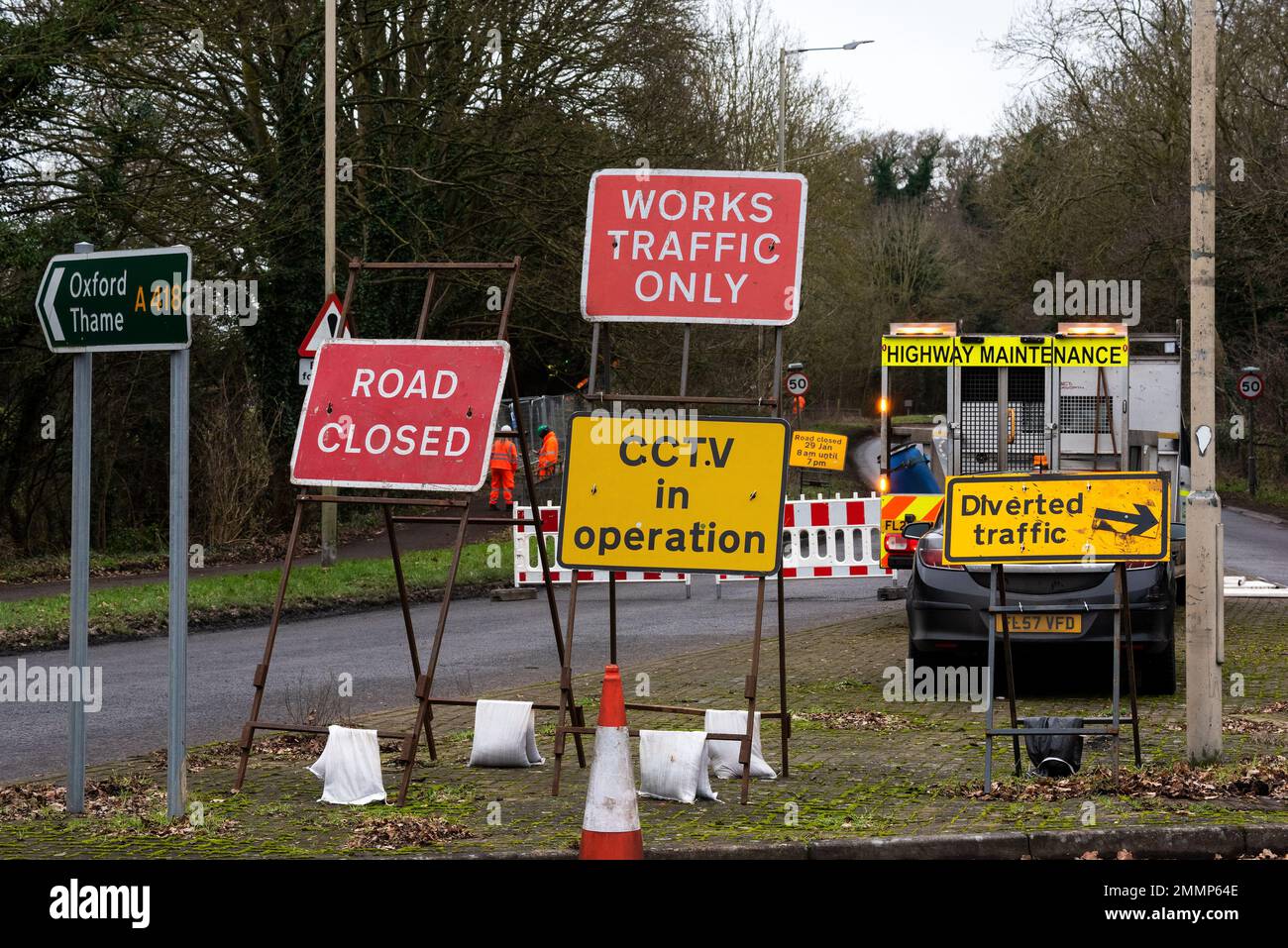 Hartwell, Aylesbury, Großbritannien. Januar 29. 2023. A413 Straßensperrung und massenhaftes Fällen von Bäumen durch HS2 Ltd. Bauunternehmer auf HS2 Land neben einem beliebten, gut genutzten öffentlichen Pfad und Radweg. HS2 gerichtliche Anordnung wegen Zäunung. HS2 Bauunternehmer mit Kettensägen schneiden die Basis von Bäumen, während Hydraulikbagger mit Greifern beim Fällen geholfen haben. Autofahrer waren verwirrt und als sie Barrieren sahen, die die Hauptstraße blockieren, mussten sie gefährliche 3-Punkte-Kurven in der Nähe einer engen Kurve beim Bugle Horn Pub machen. Kredit: Stephen Bell/Alamy Live News Stockfoto