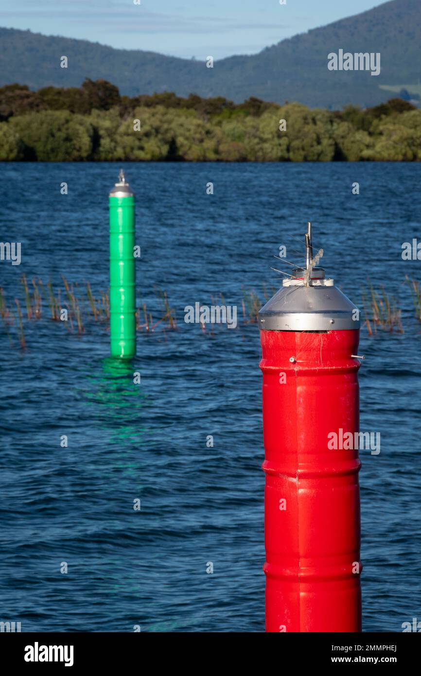 Rote und grüne Navigationsmarkierungen auf beiden Seiten des Schiffskanals, die nach Motuoapu Marina, Lake Taupo, North Island, Neuseeland führen Stockfoto