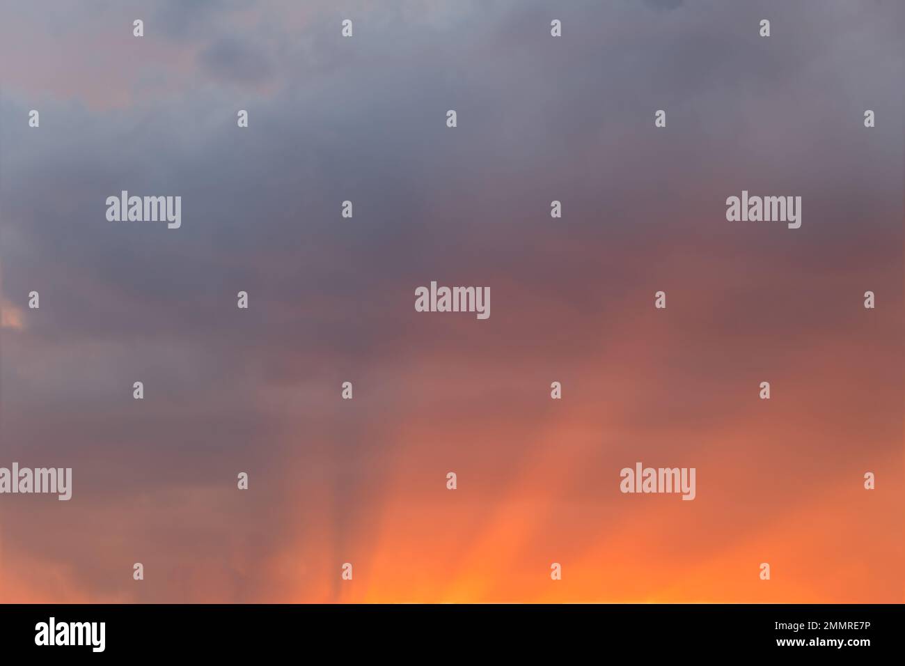 Der Himmel bei Sonnenuntergang mit Lichtstrahlen, die durch die Wolken strömen, ein sanfter, traumhafter Himmelsersatz. Stockfoto