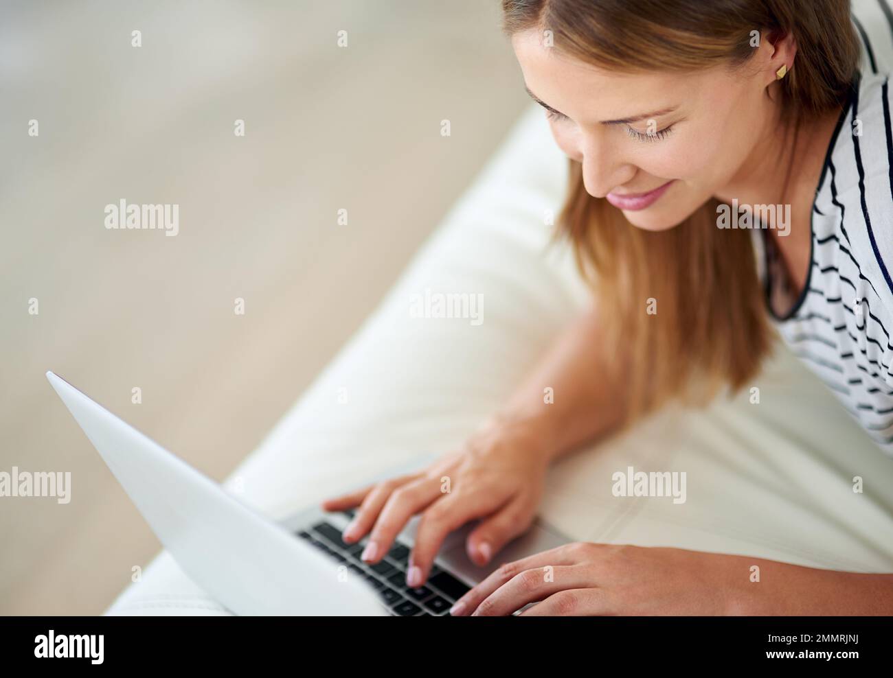 Und senden. Eine junge Frau, die zu Hause im Internet surft. Stockfoto