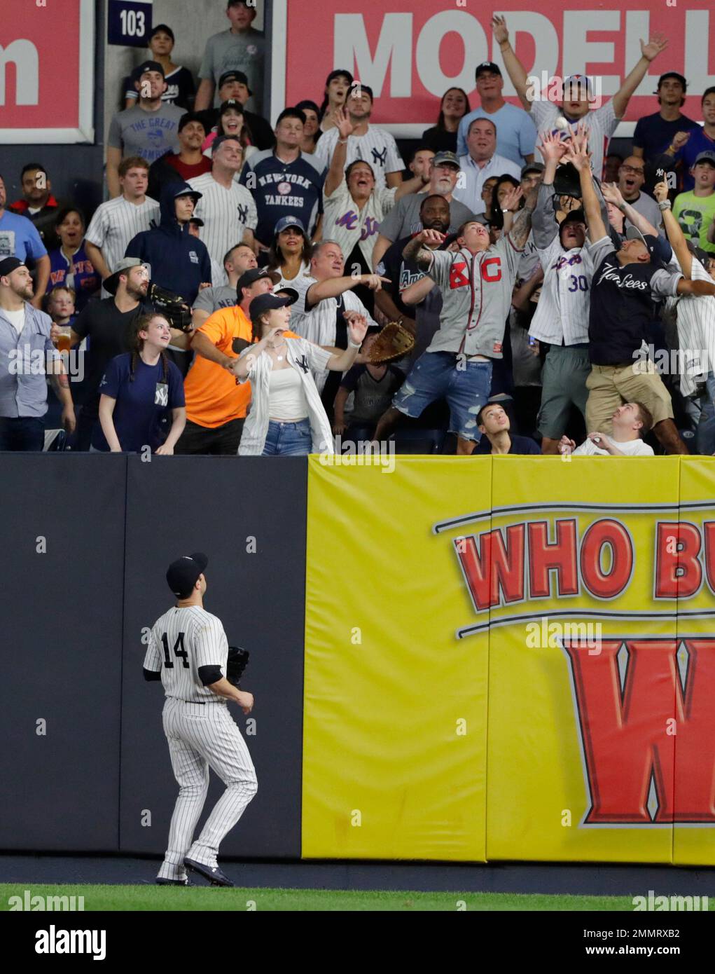 New York Yankees Neil Walker (14) watches as fans attempt to catch a ball hit by New York Mets' Brandon Nimmo for during the seventh inning of a baseball game Monday, Aug. 13, 2018, in New York. (AP Photo/Frank Franklin II) Stockfoto