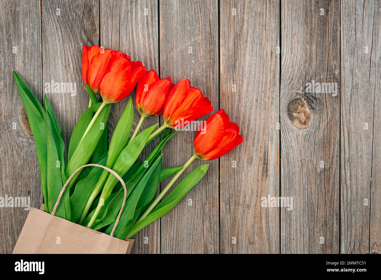 Strauß roter Tulpen auf Holzhintergrund, Draufsicht. Stockfoto