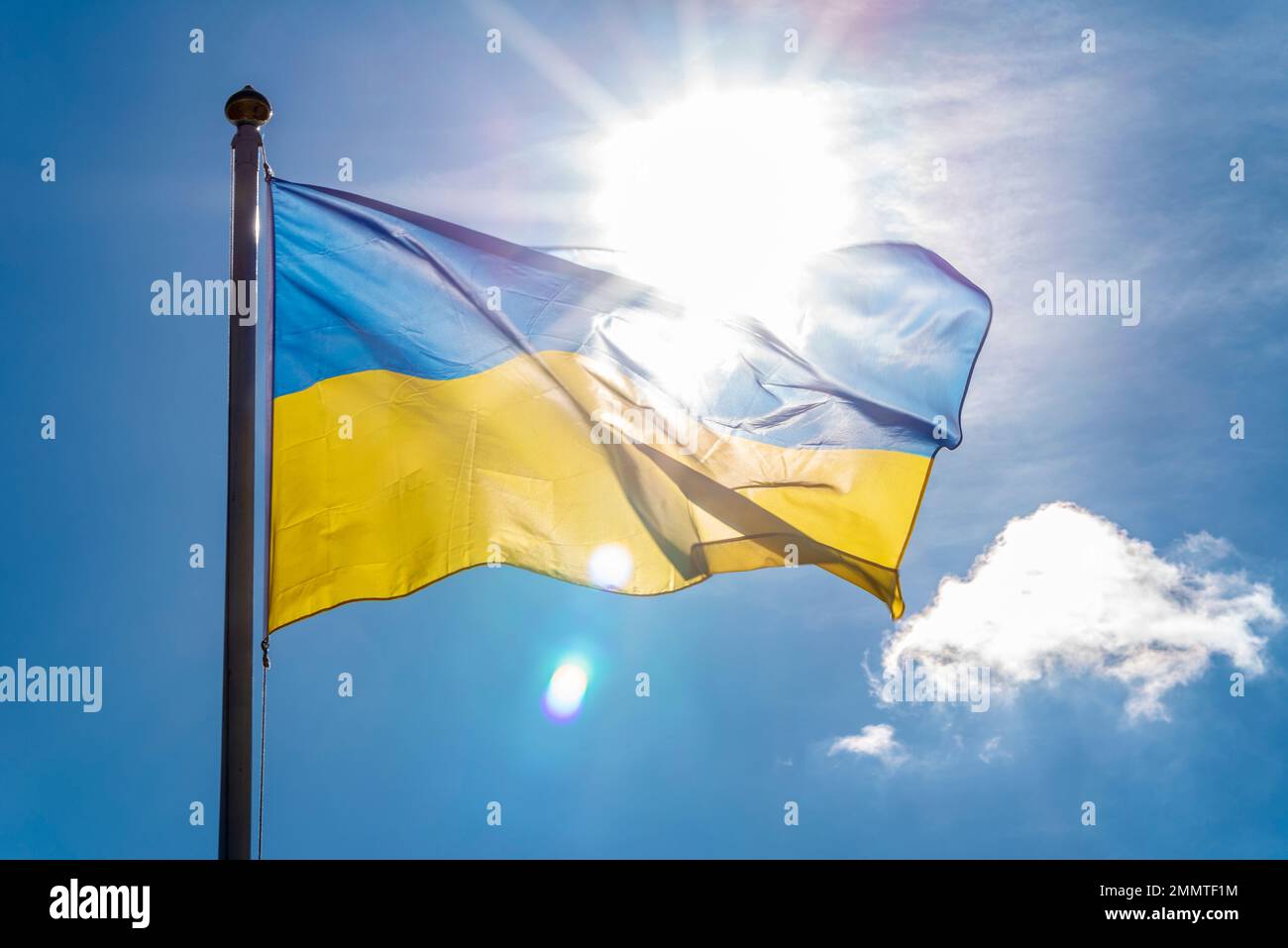 Ukrainische Flagge mit hellem Sonnenschein. Ukrainische Staatsflagge, die mit Sonne fliegt. In Gloucestershire, Großbritannien Stockfoto