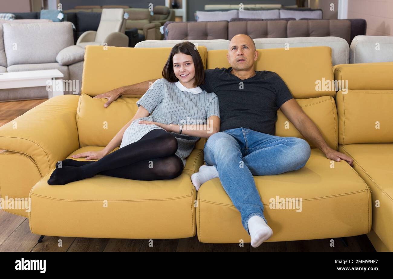 Ein Paar, das auf dem gelben Sofa sitzt Stockfoto