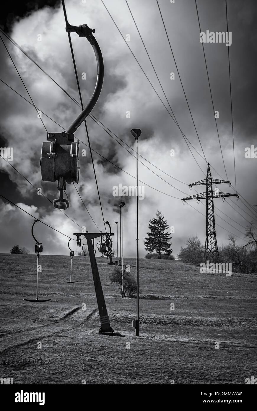 Skilift im Stillstand aufgrund von Schneemangel infolge des Klimawandels am Ende des Winters auf einem Hügel in Münsingen, Schwäbische Alb, Deutschland. Stockfoto