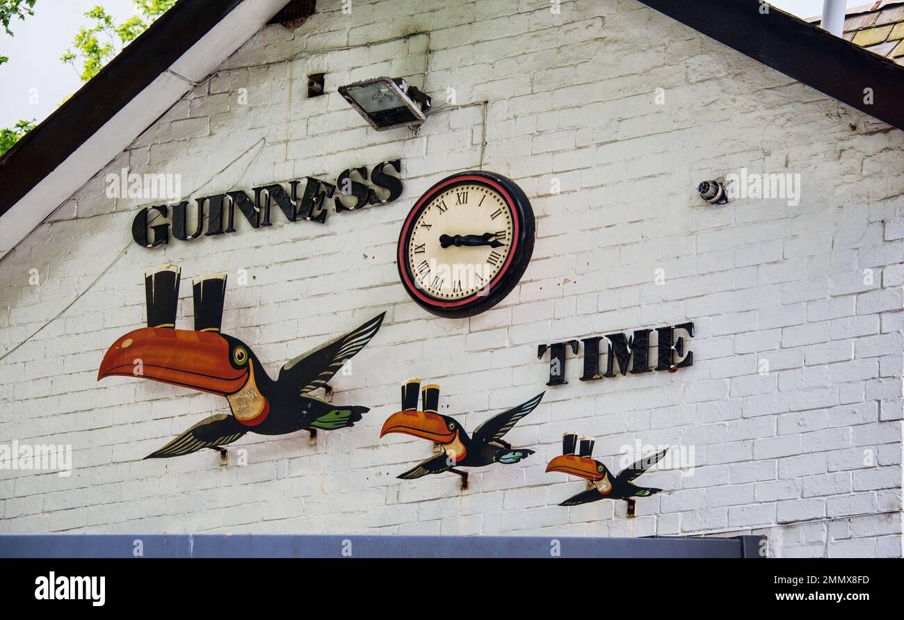 Guinness-Werbespot auf der Seite des Veranstaltungsortes mit „Guiness Time“-Fliegen von Toukanern in Verbindung mit der Marke Guinness. Stockfoto