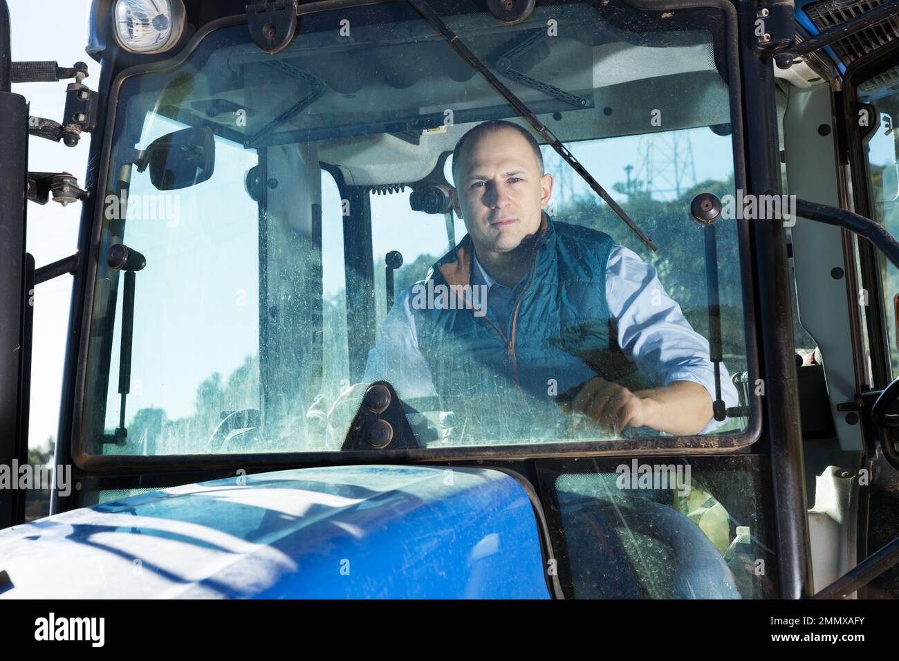 Mann sitzt in der Traktorkabine Stockfoto