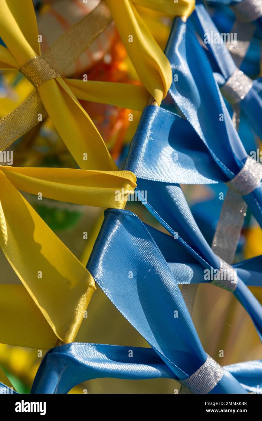 Gelb-blau, Farben der ukrainischen Nationalflagge, Stoffband am Rahmen verflochten. Symbol der Feier der Unabhängigkeit der Ukraine. Stockfoto