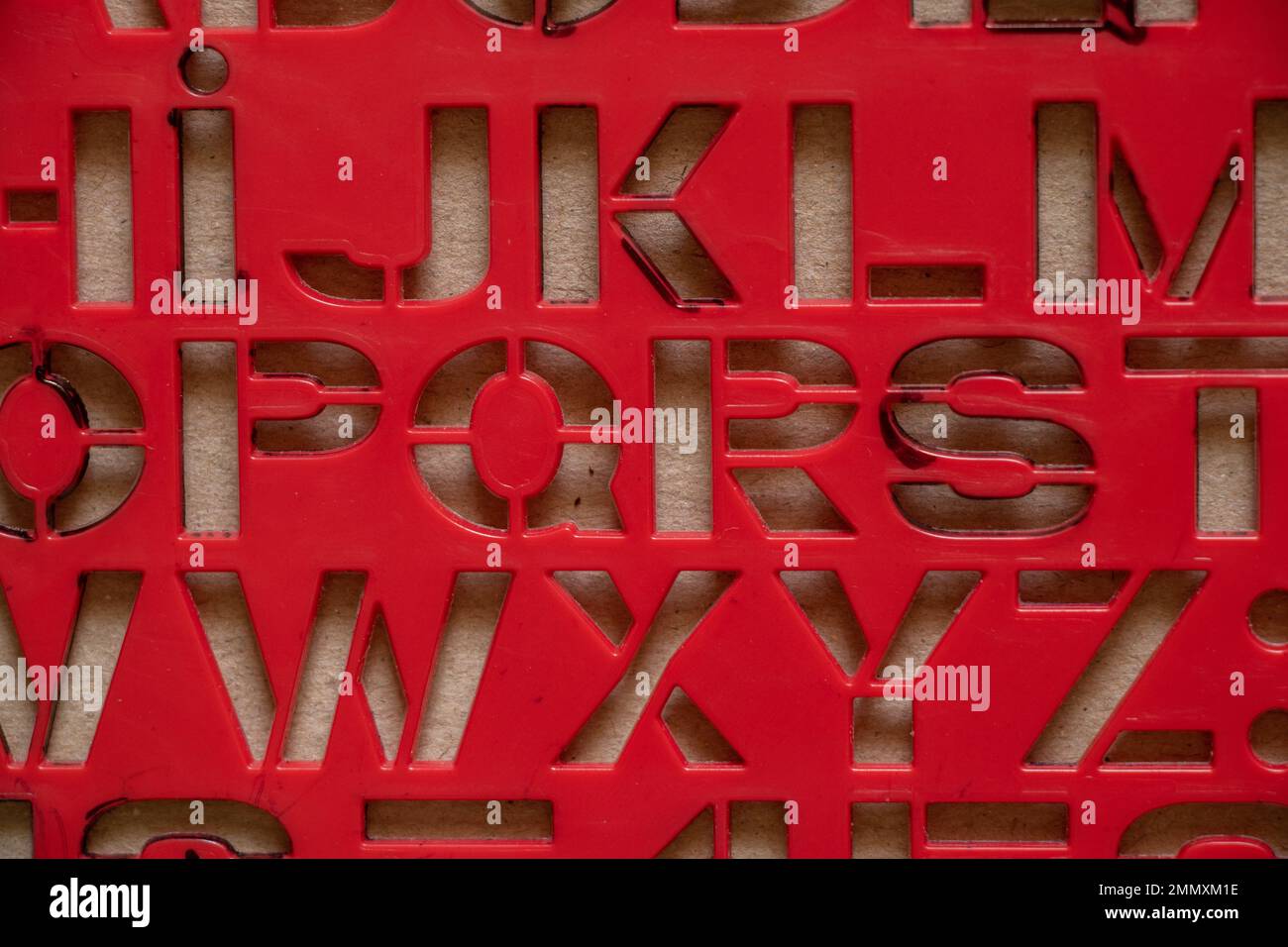 Rote Kunststoffschablone mit englischen Buchstaben als Hintergrund, englische Buchstaben Stockfoto