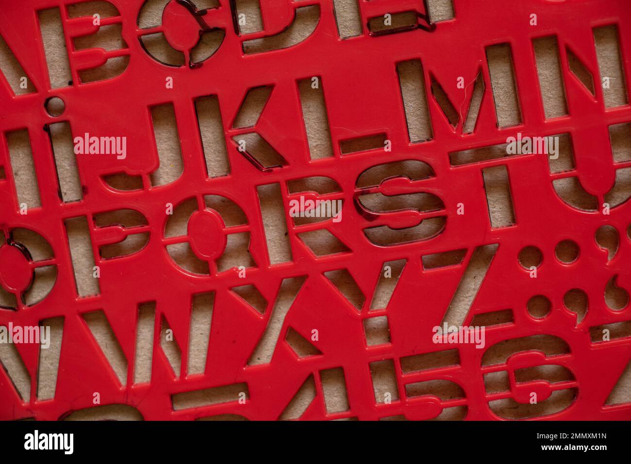 Rote Kunststoffschablone mit englischen Buchstaben als Hintergrund, englische Buchstaben Stockfoto