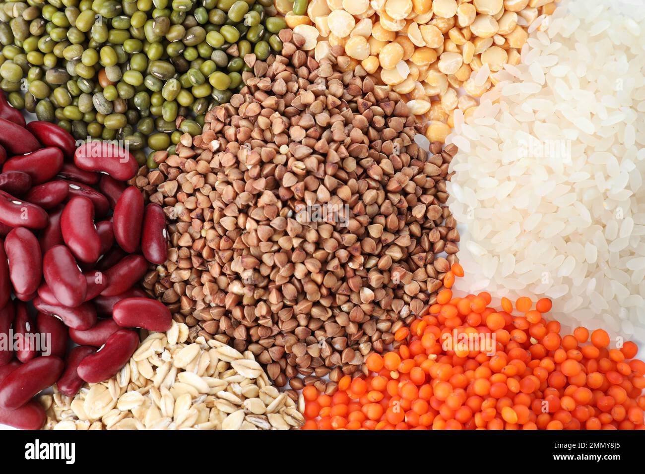 Verschiedene Arten von Hülsenfrüchten und Getreide als Hintergrund, Draufsicht. Organische Körner Stockfoto