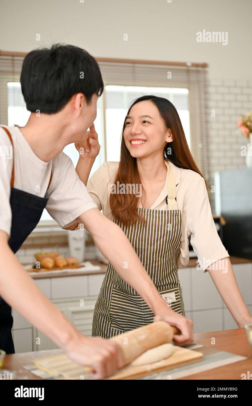 Ein junges asiatisches Paar, das beim Kochen von Speisen in der Küche  spielt, romantische Momente in der Küche verbringt, genießt das Wochenende  zu Hause. Ich Stockfotografie - Alamy