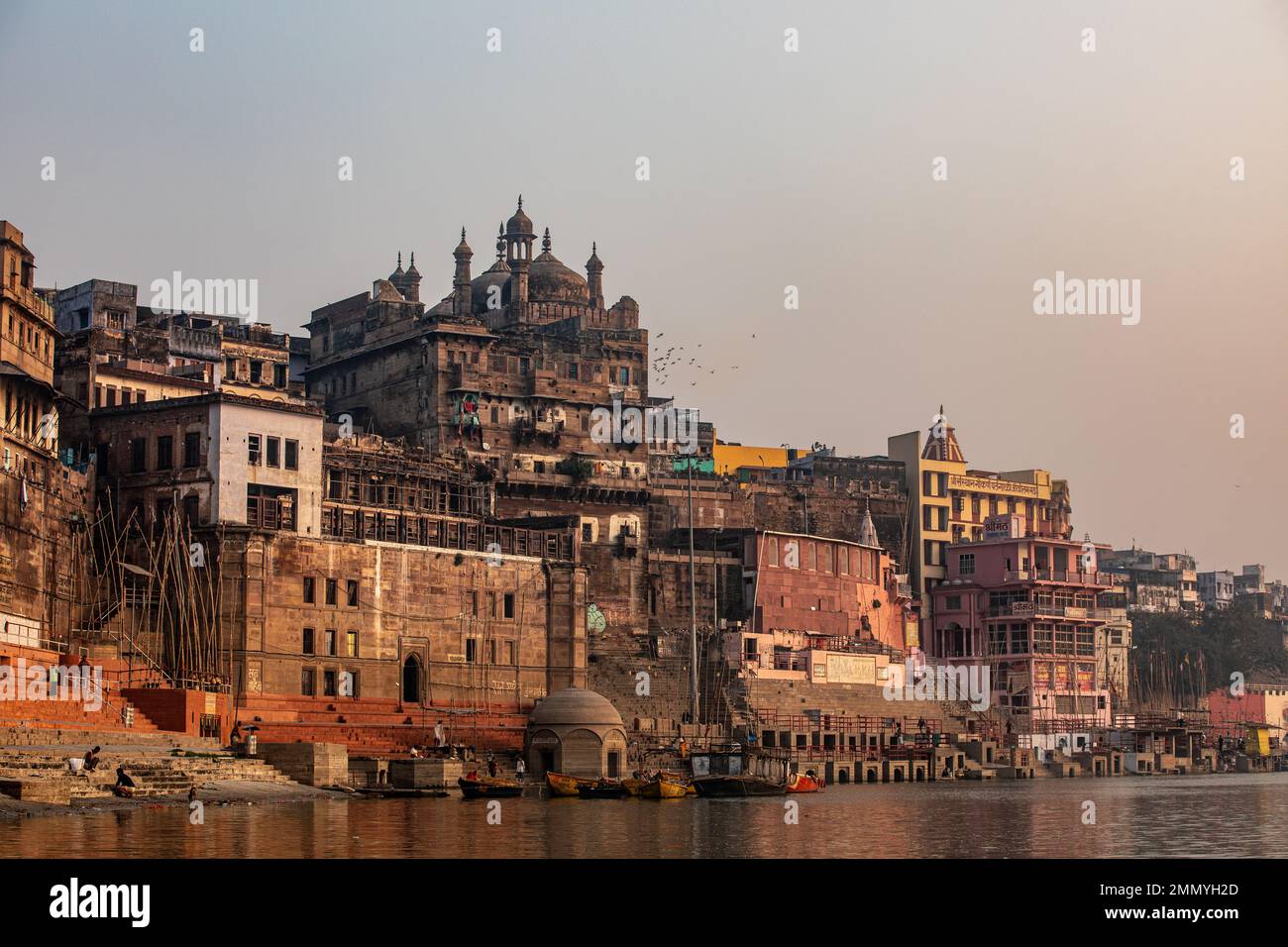 Vögel fliegen vorbei an der Alamgir-Moschee, die sich auf dem Ganges River in Varanasi, Indien, befindet Stockfoto